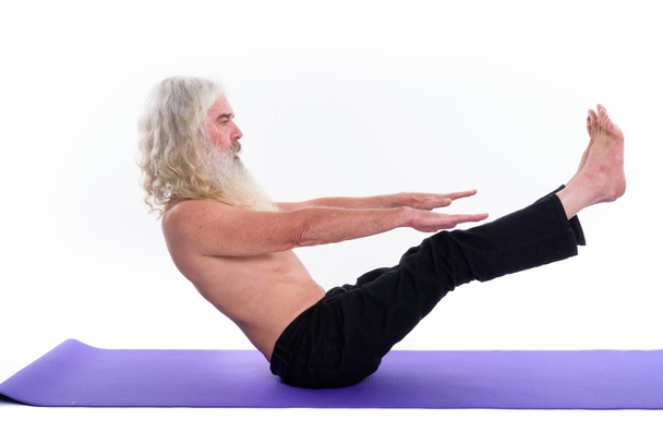 Studio shot di anziano barbuto guru uomo facendo yoga pose e stretching
 - Foto, immagini