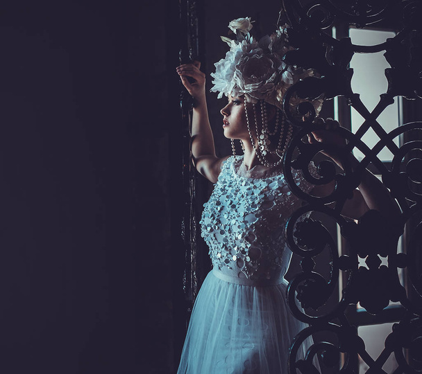Elegant wedding dress and crown. Gorgeous young woman. Tender bride in a luxurious palace. - Fotografie, Obrázek