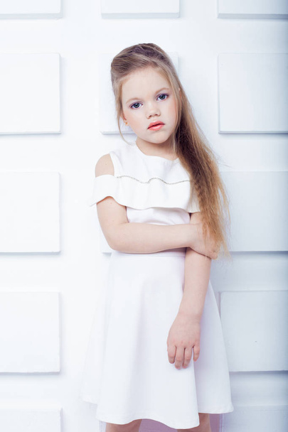 Jolie petite fille blonde portant des vêtements blancs décontractés sur un fond blanc. Style de mode
. - Photo, image