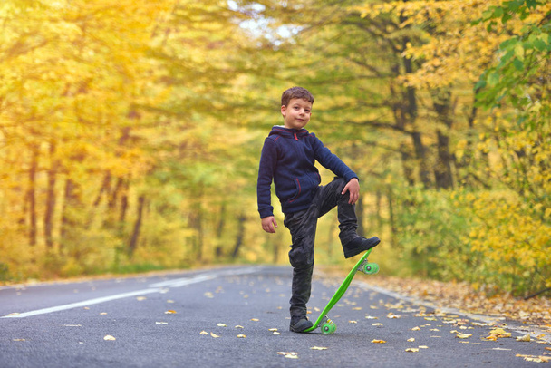 Dzieciak Skater robi deskorolka sztuczki w środowisku jesień - Zdjęcie, obraz