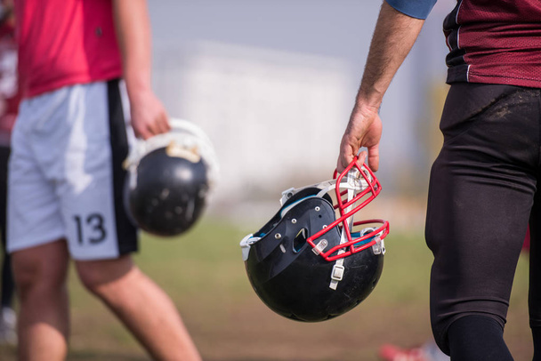 closeup shot of American football player holding black helmet at field - Zdjęcie, obraz