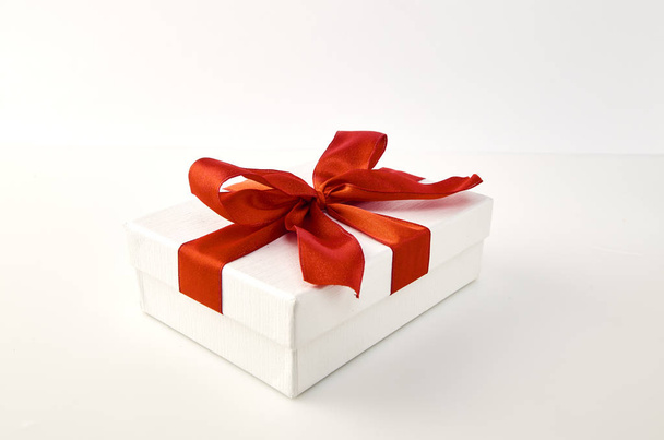 Laatikko ja iso punainen keula Joulun ja uudenvuoden päivä, Avaa punainen lahjapakkaus valkoinen tausta Lahjaideoita, tärkeä henkilö
 - Valokuva, kuva