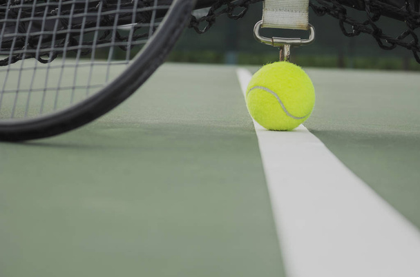tennisbal en racket op de tennisbaan, close-up tennisbal in Hof - Foto, afbeelding