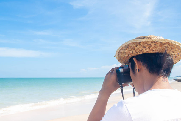 Закройте вид сзади на человека, снимающего фото на пляже, Счастливого праздника
 - Фото, изображение