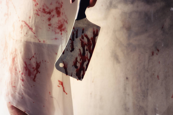 Un meurtrier tenant un couteau enduit de sang prêt à attaquer pour tuer sa victime. Disparue kidnappée. Dans un bâtiment abandonné. Meurtre et concept Halloween
. - Photo, image