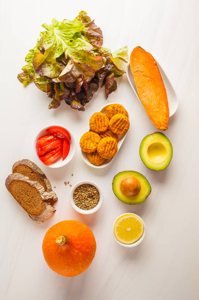 Ingredientes veganos para ensalada o sándwich: verduras, albóndigas vegetales y pan. Concepto alimentario vegetal
. - Foto, Imagen