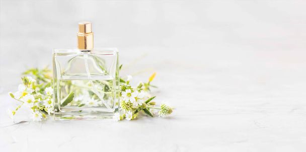 Parfumfles met witte bloemen en kopie ruimte, witte floral geur parfum in doorzichtige fles - Foto, afbeelding