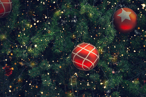 Vintage kerstboom met de rode bal decoratie en sparkle licht. Kerstmis en Nieuwjaar vakantie achtergrond. Vintage kleurtoon. - Foto, afbeelding