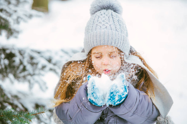 Cute little girl smiling and playing in winter with snow. - Foto, Imagen