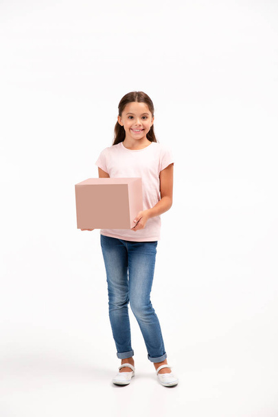 little girl with box isolated over white background. Copy space on the box. - Foto, afbeelding