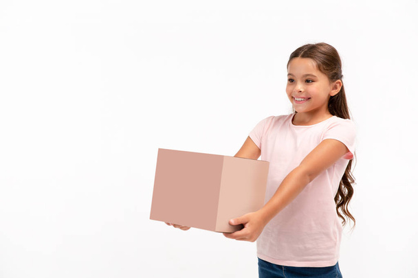 little girl with box isolated over white background. Copy space on the box. - Photo, Image