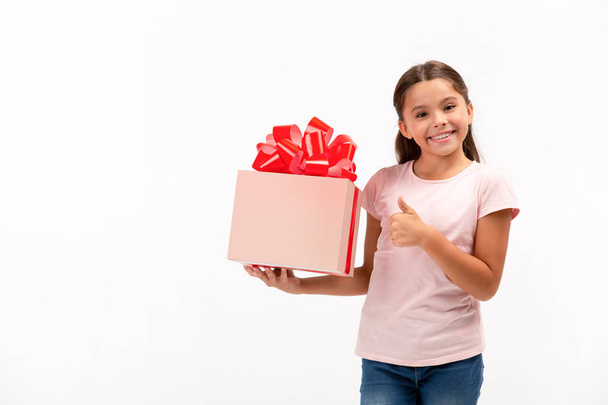 Portret van gelukkig klein meisje met de doos van de gift op witte achtergrond. Ruimte in het vak kopiëren - Foto, afbeelding