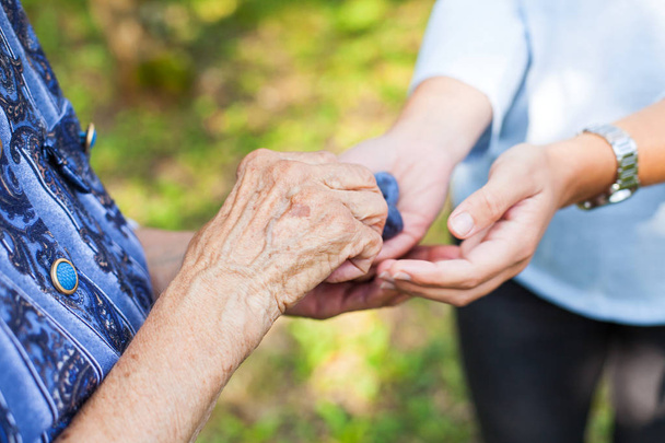 Κοντινό πλάνο εικόνα ζαρωμένο χέρι ηλικιωμένων και μια χούφτα φάρμακα και βιταμίνες - Φωτογραφία, εικόνα
