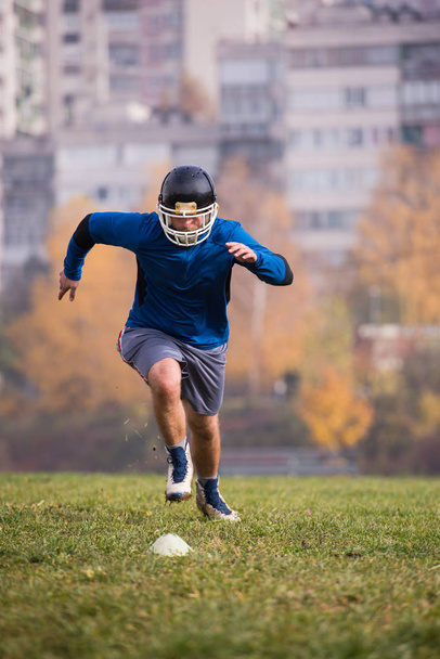 молодий американський футболіст, який грає на полі під час тренування. - Фото, зображення