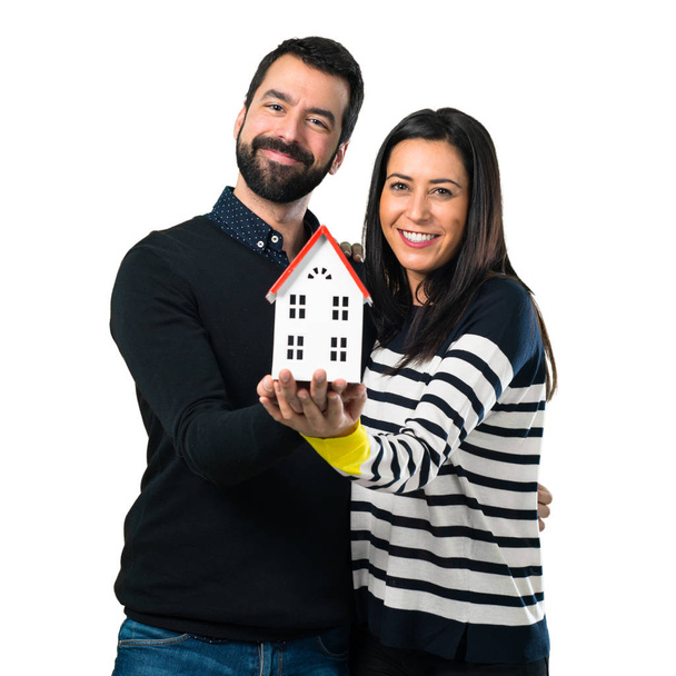 Couple holding a little house on white background - Zdjęcie, obraz