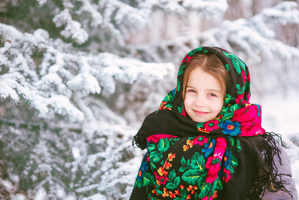 portrait of a child girl in a headscarf in the Urs style on the background of snow and forest. Russia, frost, fairy tale - Fotografie, Obrázek