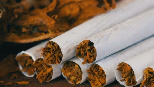 Lähikuva od kotitekoisia savukkeita tai roll-up vieressä kuivaa tupakkaa lehdet täytetyt hienonnettu tupakka
 - Materiaali, video