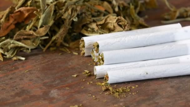 Cigarros caseiros ou roll-up recheado com tabaco estão em uma mesa ao lado de folhas de tabaco secas
 - Filmagem, Vídeo