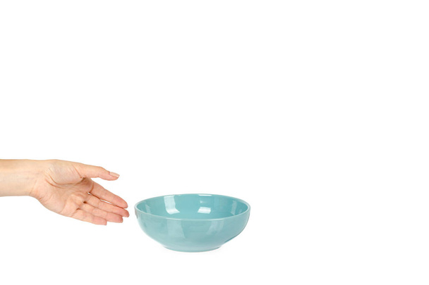 Blue empty ceramic bowl with hand isolated on white background, copy space template. - 写真・画像
