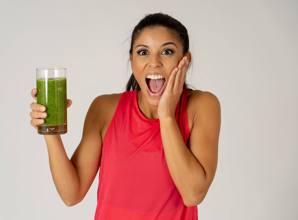 Fitness woman happy smiling holding glass of green vegetable smoothie after fitness running workout isolated on gray background in Beauty Health Fitness Diet Nutrition and healthy Lifestyle concept. - Fotografie, Obrázek