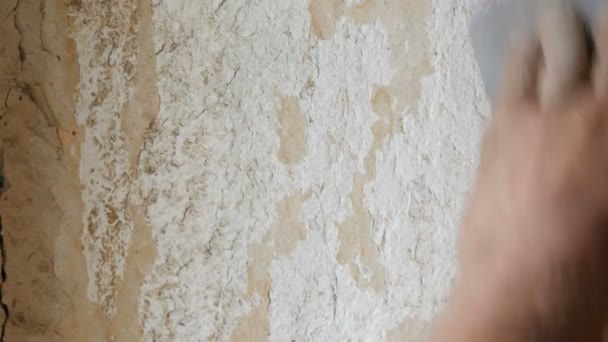 Mann beim Schälen alter Tapeten mit speziellem Spachtel. gelb, marode Tapete an der Wand, Reparatur zu Hause in Nahaufnahme - Filmmaterial, Video