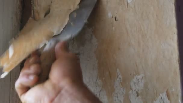 Homem descascando papel de parede velho com espátula especial. Amarelo, papel de parede decrépito na parede, reparação home close-up
 - Filmagem, Vídeo