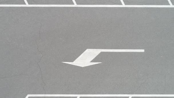 video z bílé malované šipku na asfaltovou silnici na parkování - Záběry, video