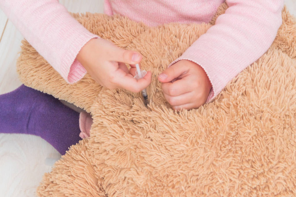 Kind, ein Mädchen schießt auf den Spielzeugbär, die Insulinspritze - Foto, Bild