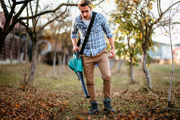 Garden worker using leaf blower outside - Foto, Bild