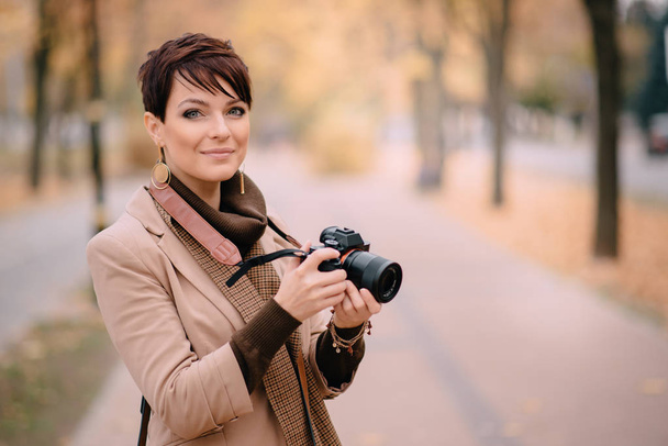 young female photographer looking at camera and smiling - Valokuva, kuva