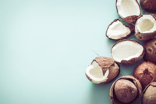 Fresh coconut halves on a blue background, pop art design. Top view, close-up, creative concept - Fotó, kép