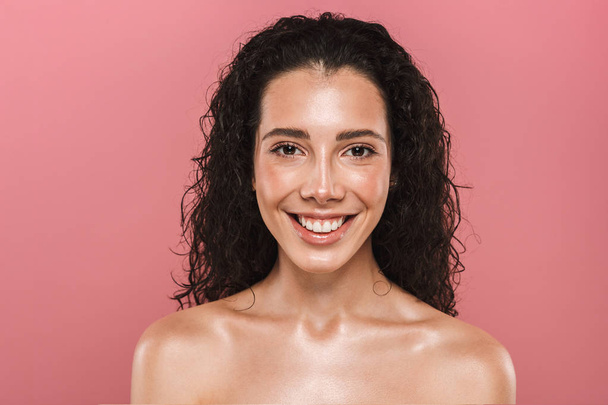 Portrait of pretty cheerful happy young woman with healthy skin posing isolated over pink background. - Фото, зображення