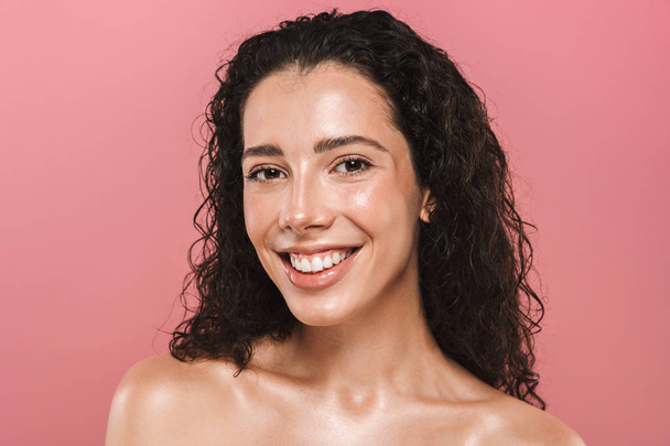 Portrait of pretty cheerful happy young woman with healthy skin posing isolated over pink background. - Foto, afbeelding