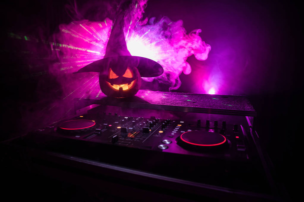 Calabaza de Halloween en una mesa de dj con auriculares sobre fondo oscuro con espacio para copiar. Felices decoraciones del festival de Halloween y concepto de música. Espacio vacío. Enfoque selectivo
 - Foto, imagen