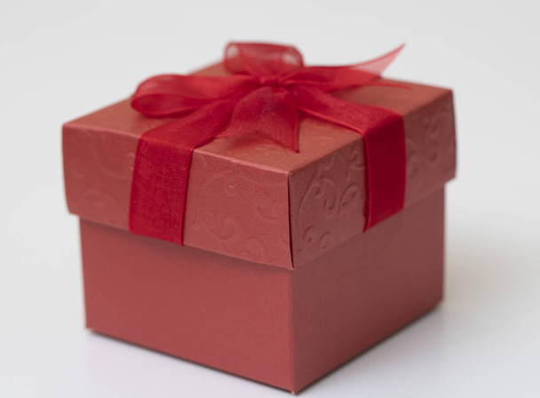 Κόκκινο δώρο κουτί με κόκκινη κορδέλα που απομονώνονται σε λευκό φόντο., για να στείλετε το καλό συναίσθημα σε ειδικό - Φωτογραφία, εικόνα