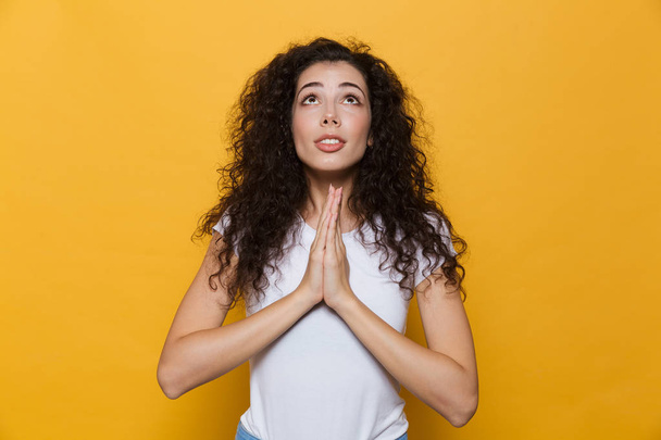 Photo of beautiful excited young cute woman posing isolated over yellow background showing hopeful please gesture. - Foto, afbeelding