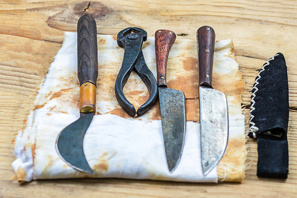 instrumentos de cirugía medieval para el tratamiento de la odontología fila de cuchillos pinzas contra el fondo de manchado con viejas hojas de sangre
 - Foto, Imagen