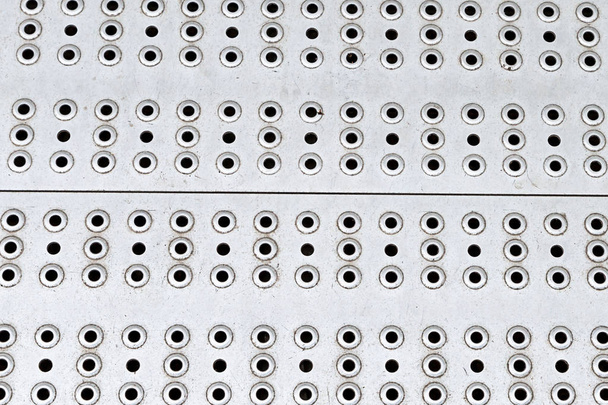 superficie de metal perforado patrón muchos agujeros redondos base gris diseño base brillante industrial
 - Foto, Imagen