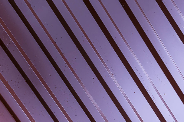 fundo metal com nervuras close-up perfil parte de uma cerca telhado costelas paralelas cobertas com gotas de chuva
 - Foto, Imagem