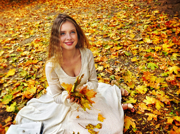 Autumn fashion dress woman sitting fall leaves city park outdoor. - Photo, Image