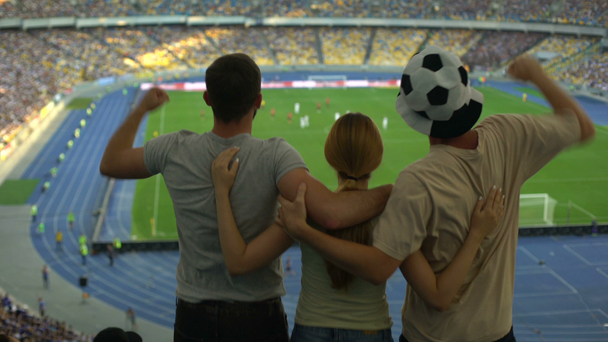 Football fans jumping at stadium, friends cheering victory of favorite team - Felvétel, videó