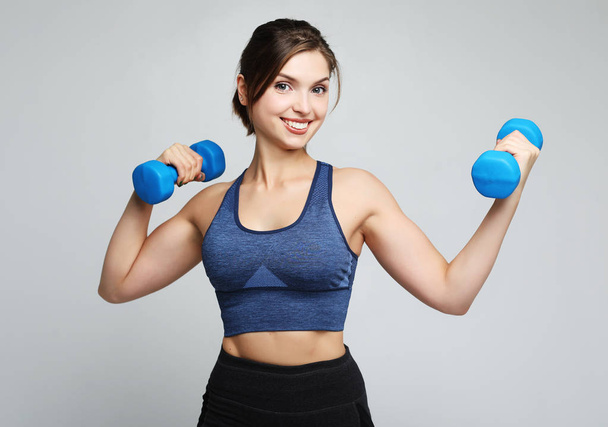 sport and people concept: Young girl athlete, fitness with dumbbells on white background - Zdjęcie, obraz