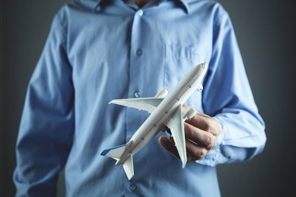 Чоловік тримає іграшковий літак. Концепція подорожей
 - Фото, зображення