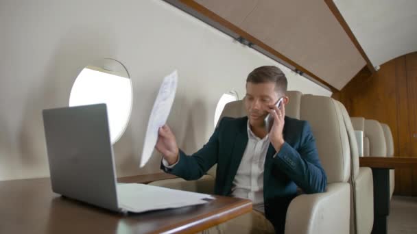 μιλάμε το κινητό τηλέφωνο συνεργάτη σύνδεσης αεροσκαφών jet travel άνθρωπος των επιχειρήσεων - Πλάνα, βίντεο