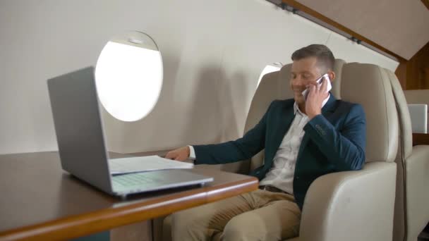 携帯電話パートナー接続ジェット航空機旅行で語っている成熟した起業家 - 映像、動画