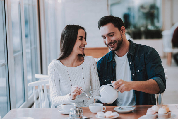 Teapot. Bonding. Cupcake. Leisure Time.Together in Cafe. Tea. Cheerful Girl. Happy Together. Smiling People. Love Story. Tea Party.Have Fun. Enjoyment. Guy and Girl. Good Relationship. Happy Holidays. - Foto, imagen
