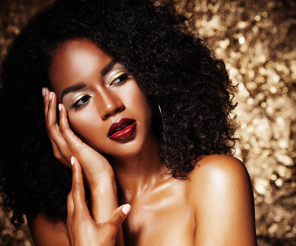 Young elegant african american woman with afro hair. Glamour makeup. Golden Background. - Foto, imagen