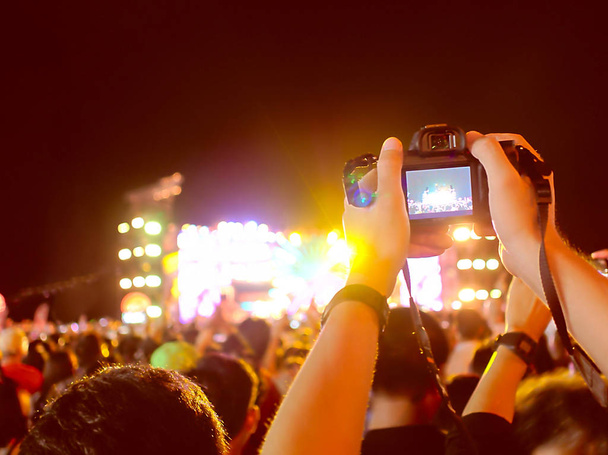 Handen van niet-geïdentificeerde video opnemen met digitale camera tijdens muziek festival concert. - Foto, afbeelding