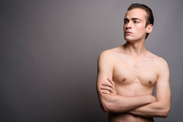 Giovane bell'uomo a torso nudo con le braccia incrociate pensando
 - Foto, immagini