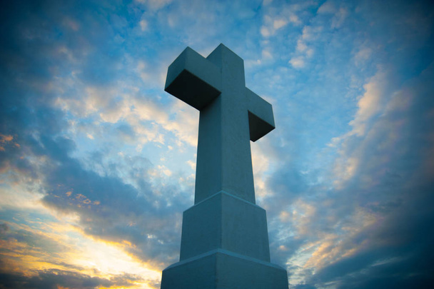 Masywne chrześcijańskiej krzyż w błękitne niebo, wykonane z kamienia - Zdjęcie, obraz
